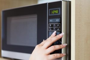 mano su pulsanti microonde