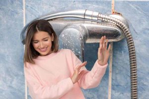 Rubinetto con calcare e donna con mani avanti