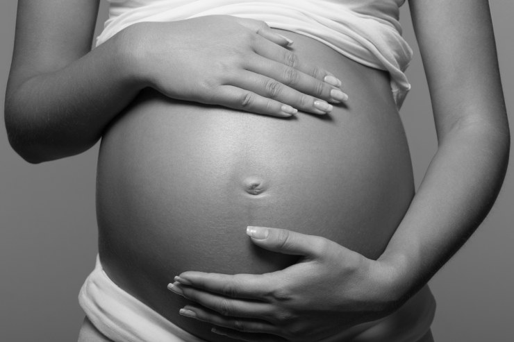 Donna incinta in bianco e nero con primo piano sulla pancia