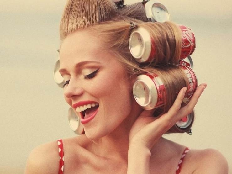 Ragazza con lattine di Coca Cola al posto dei bigodini