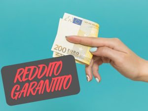 Donna banconote in mano scritta Reddito Garantito