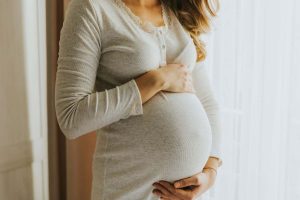 Ragazza incinta abbraccia la pancia