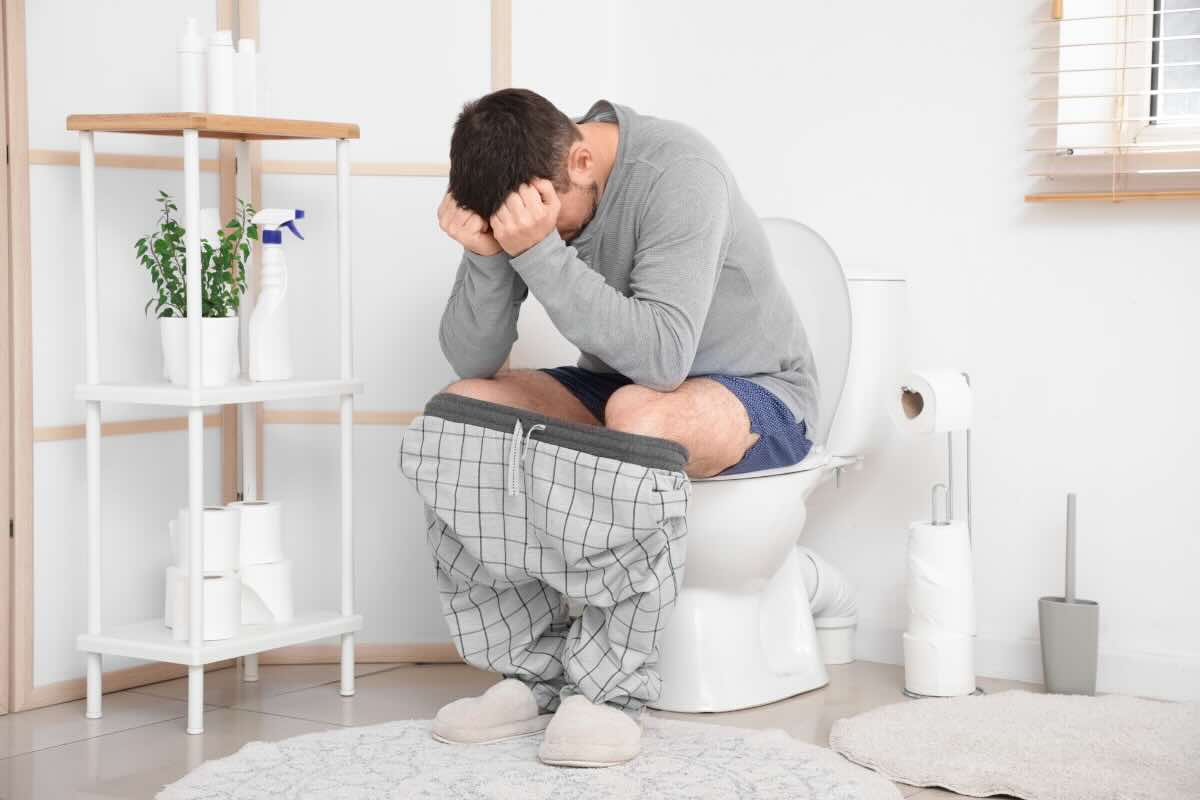 uomo seduto in bagno disperato