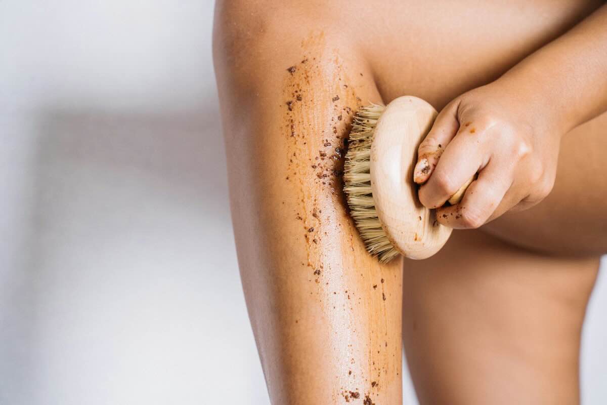parte di gamba con spugna che passa lo scrub