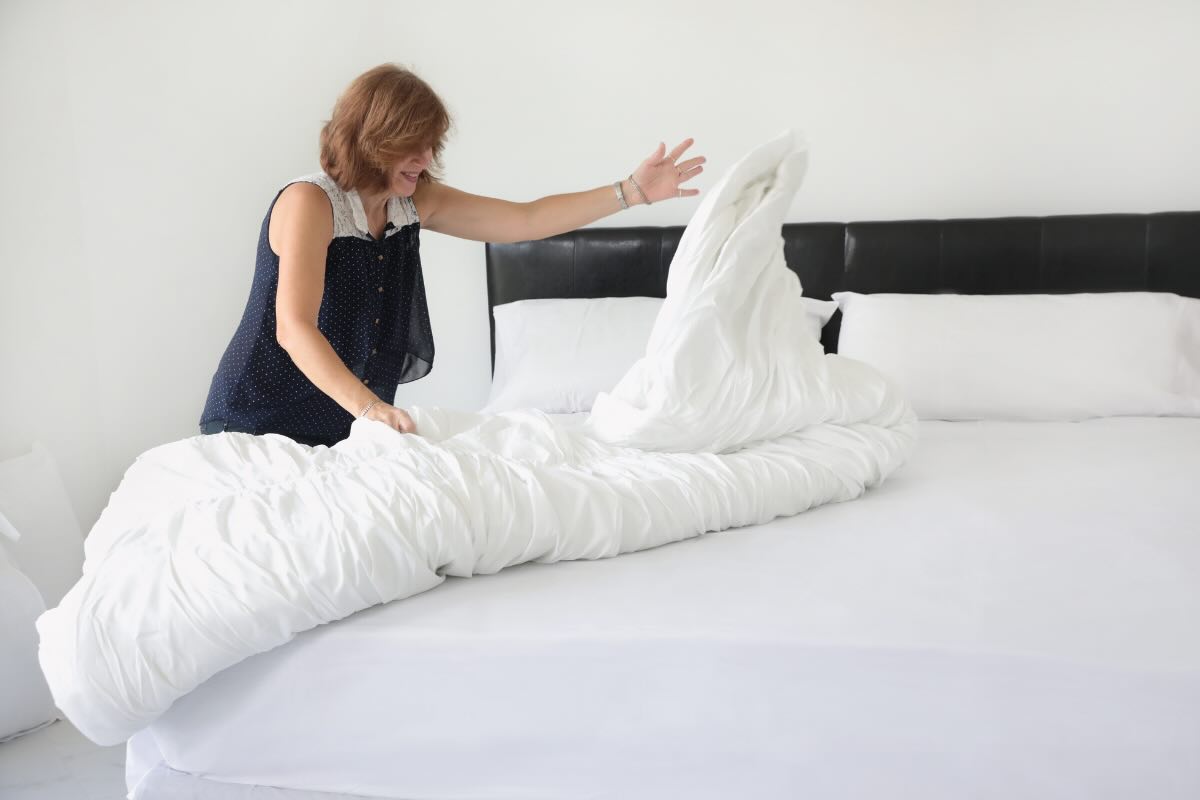 donna che sistema il letto