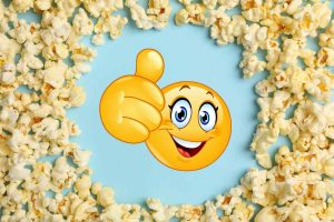 Sfondo azzurro con sopra popcorn e emoji felice