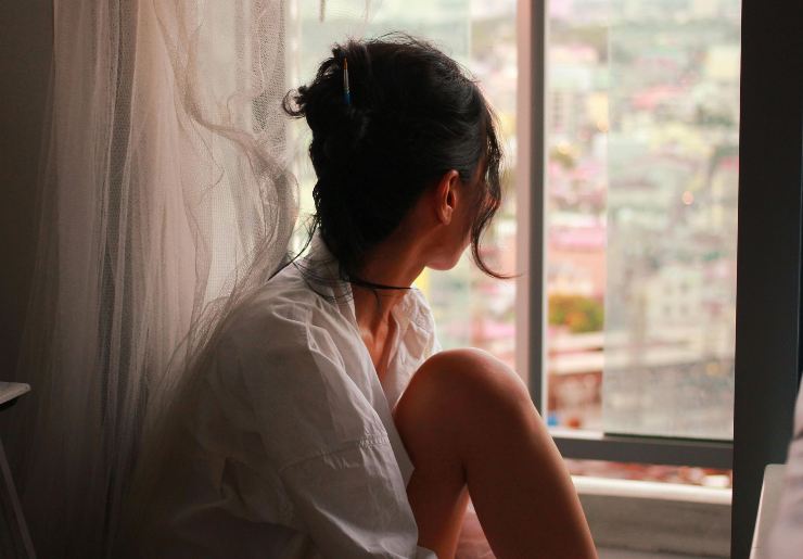 Ragazza guarda fuori dalla finestra