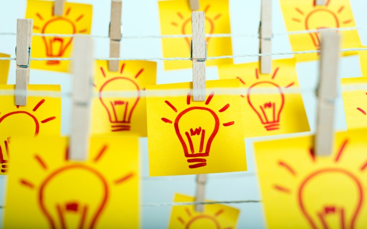 Post-it con delle lampadine disegnate, appesi a delle corde con una molletta: concetto di idea