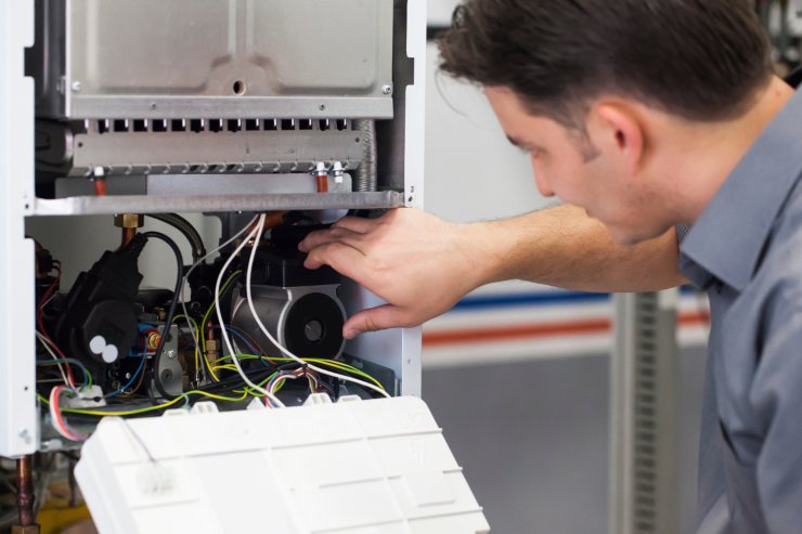 Tecnico della caldaia che controlla l'apparecchio dall'interno