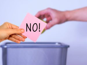 sfondo mano che getta albedo in cestino e mano con bigliettino con scritto no