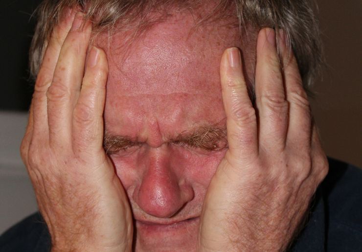 uomo disperato con le mani in faccia
