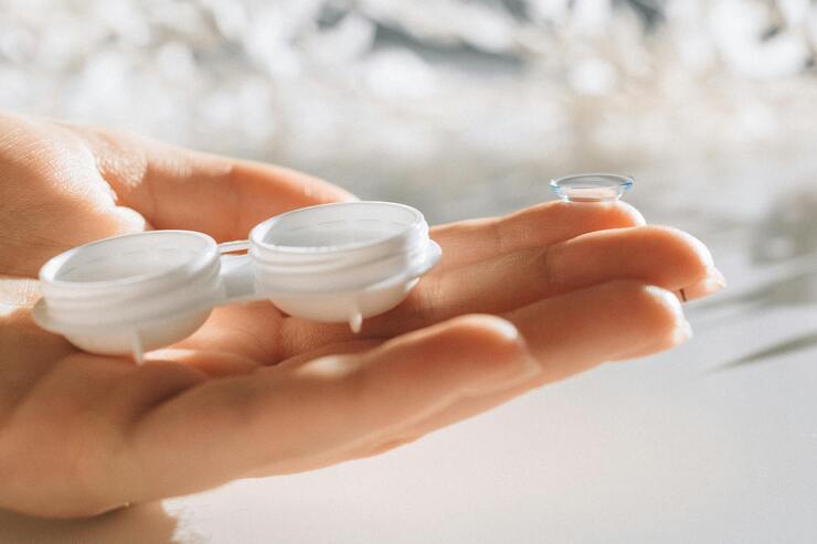 Mano di donna con lenti a contatto sulle dita
