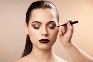 Donna truccata che mette eyeliner