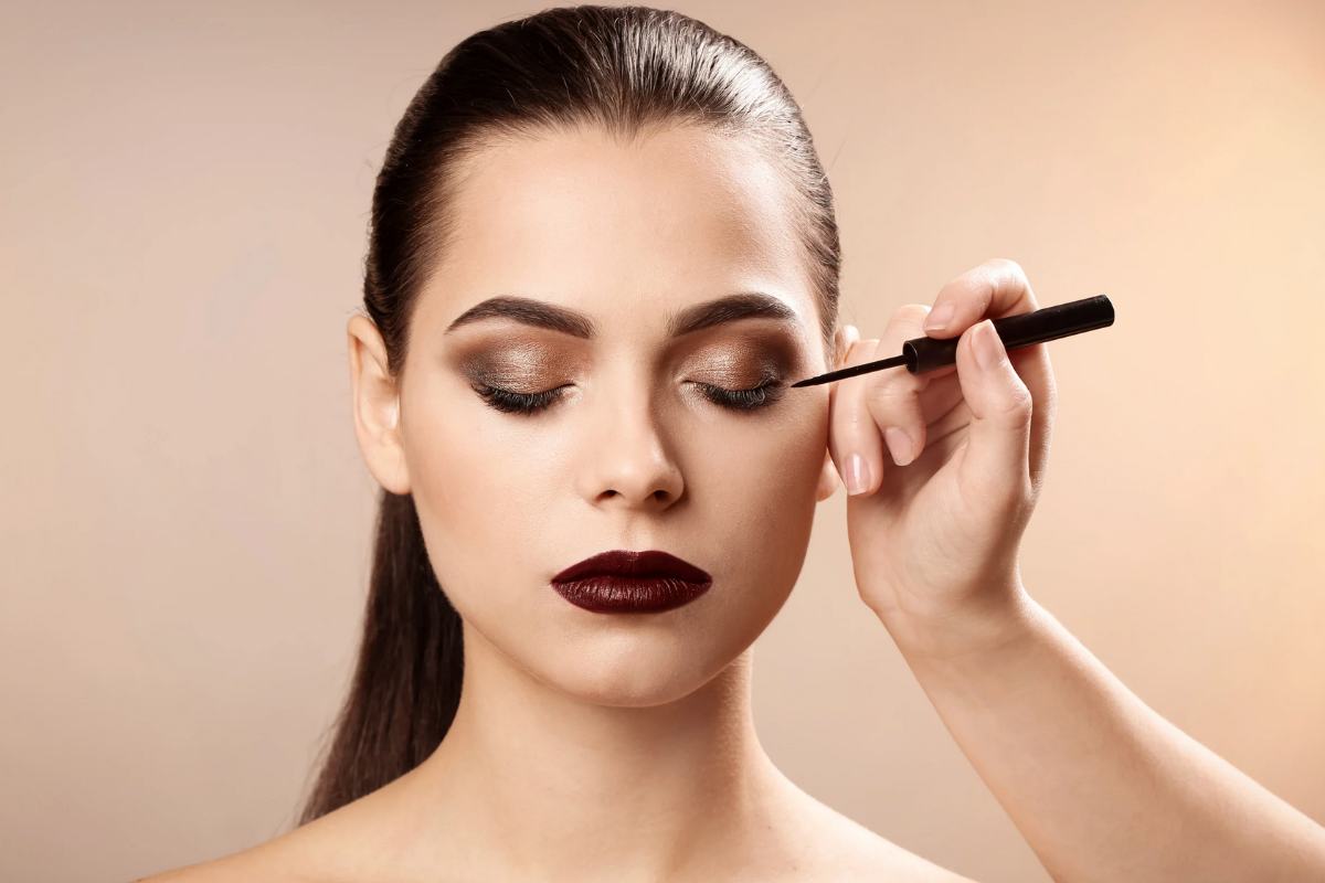 Donna truccata che mette eyeliner