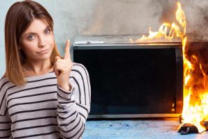 forno a microonde che brucia e donna che indica