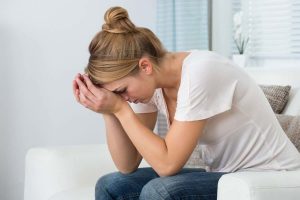 Donna afflitta con mani sulla testa