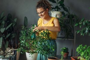 Ragazza sorridente cura piante in vaso
