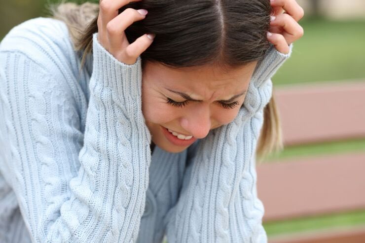 Ragazza con mani sulle orecchie disperata