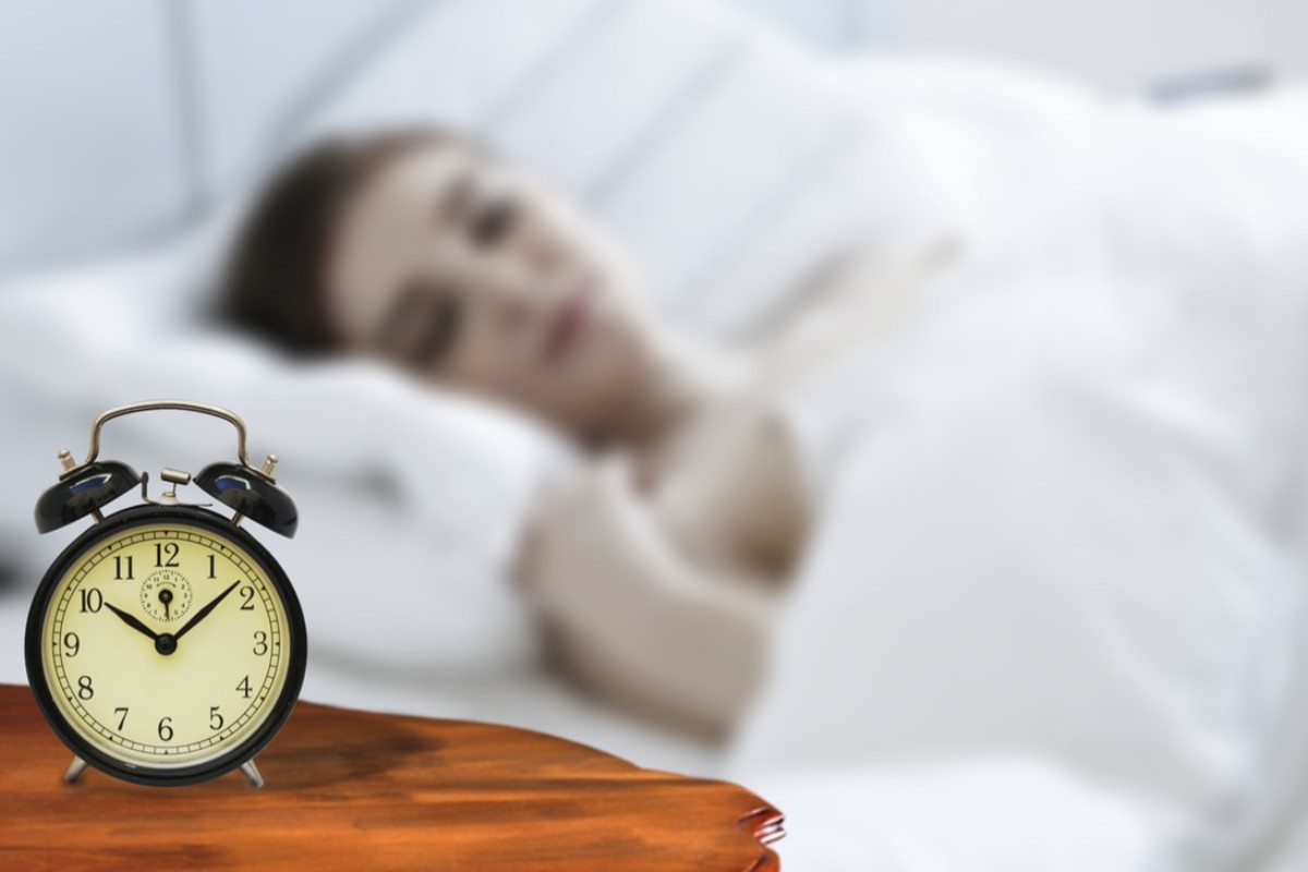 sveglia e donna che dorme nel letto