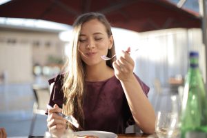 Ragazza con il metabolismo veloce che mangia soddisfatta