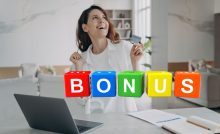 donna felice davanti a pc e scritta bonus