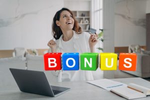 donna felice davanti a pc e scritta bonus