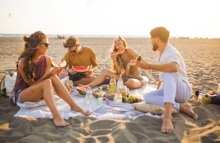 amici che mangiano in spiaggia