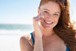 ragazza con crema solare sul viso