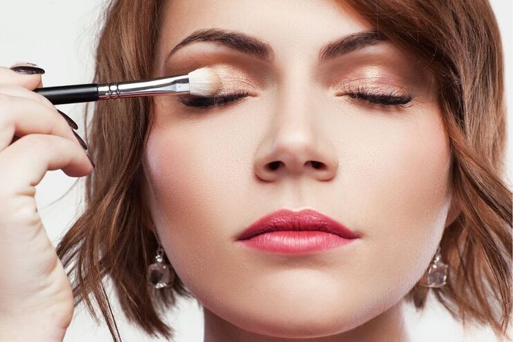 Donna applica ombretto colore marrone