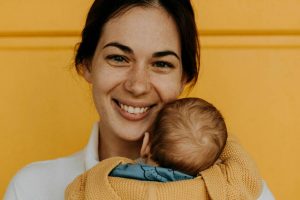 Mamma sorridente con in braccio un neonato