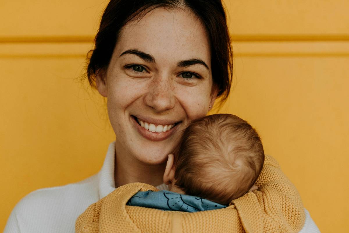 Mamma sorridente con in braccio un neonato