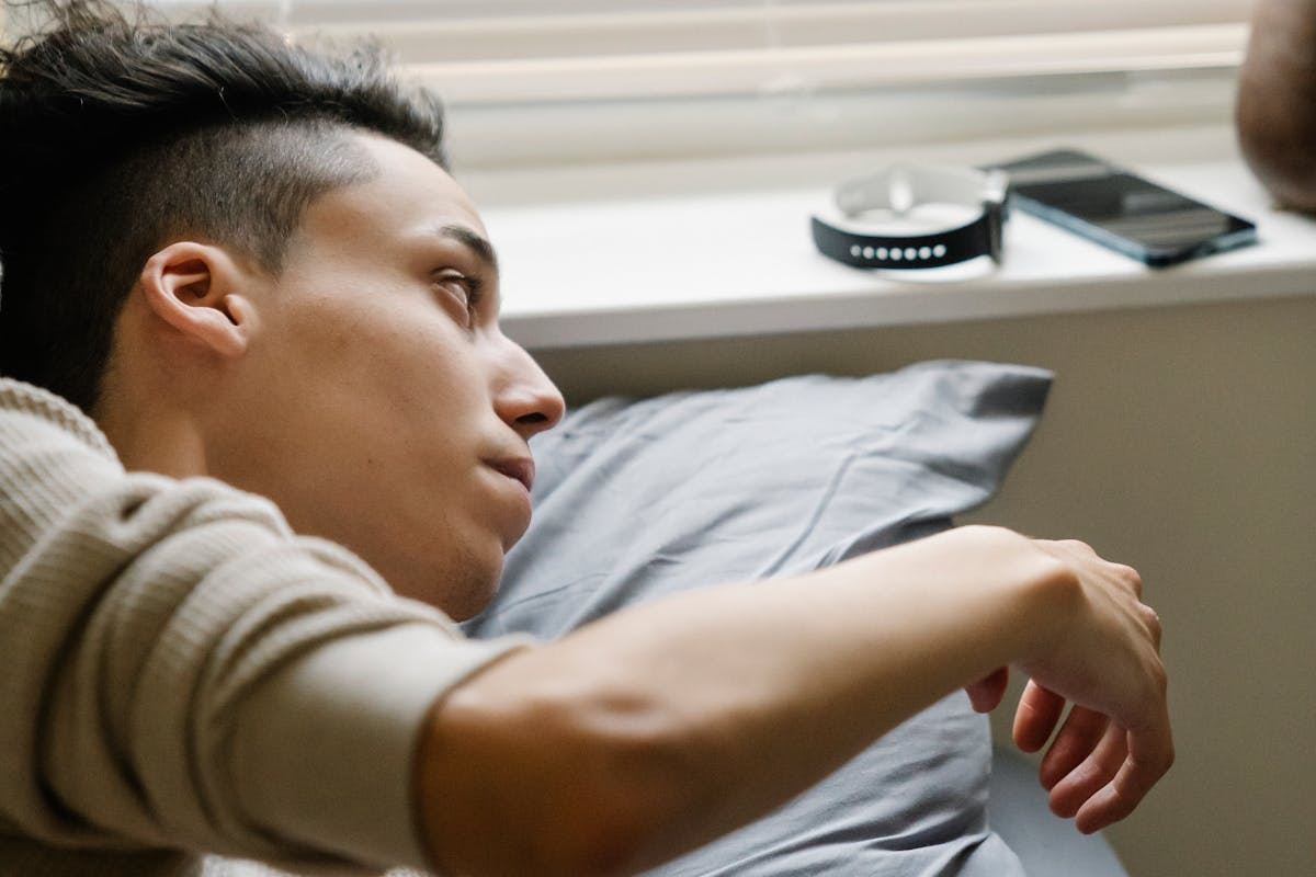 uomo appena sveglio che si tende verso il cellulare