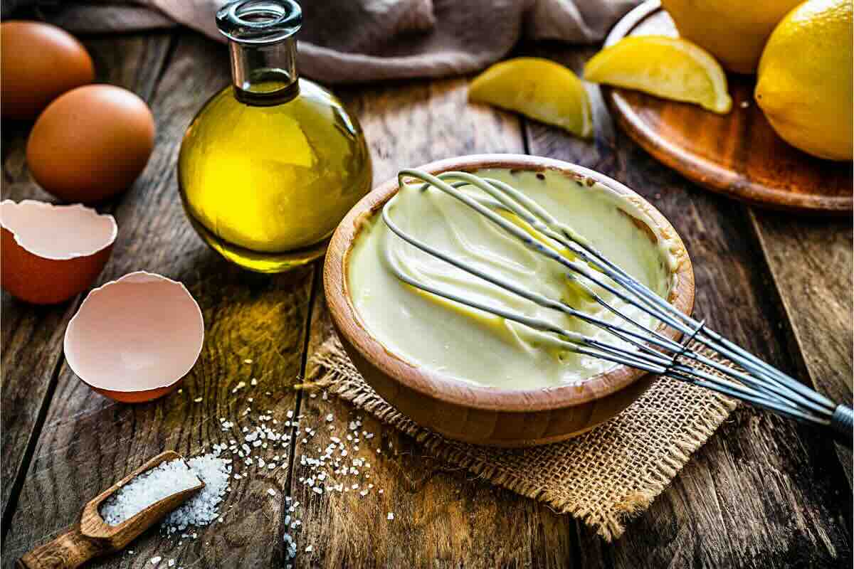 Olio, uova, limone, ciotola con maionese, frusta