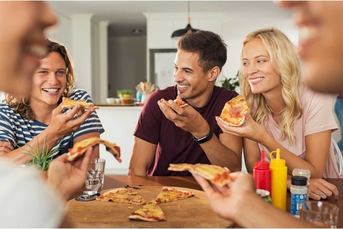Amici mangiano pizza a casa
