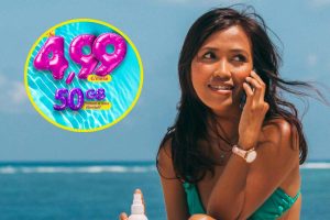 Ragazza al mare che parla al telefono e, in evidenza, la grafica della promozione di Postemobile